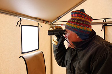 Tom Duffus watching the early spring mating ritual of the sharp-tailed grouse on their booming grounds. Photo by Ann Simonelli/The Conservation Fund.