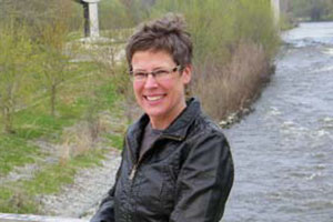 Kimberly Gleffe stands on the pedestrian bridge over the Milwaukee River adjacent to the protected parcel. Photo courtesy River Revitalization Foundation. 